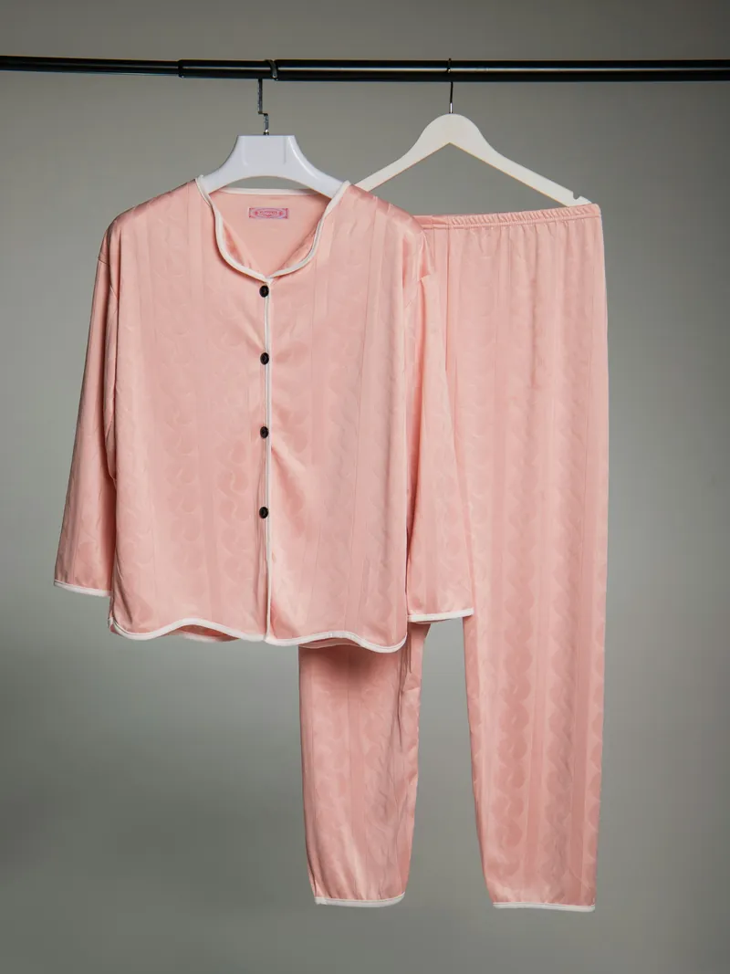 Blush piped cotton pajama shirt and trousers on a hanger