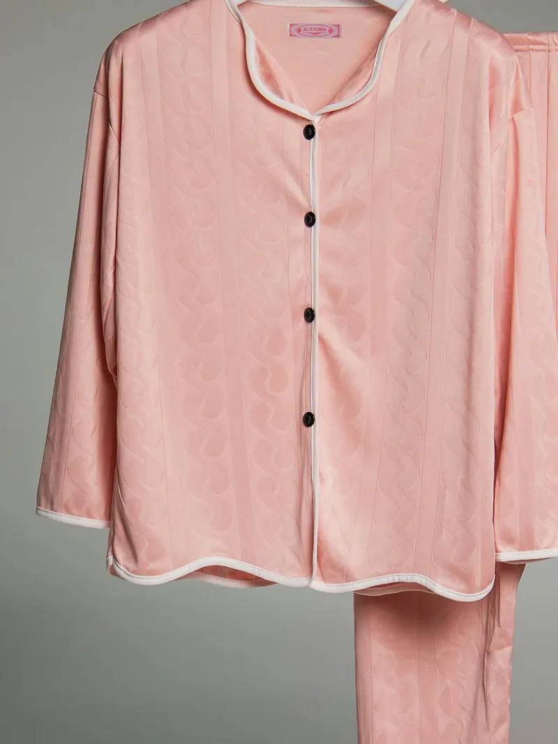 Blush piped cotton pajama shirt and trousers on a hanger